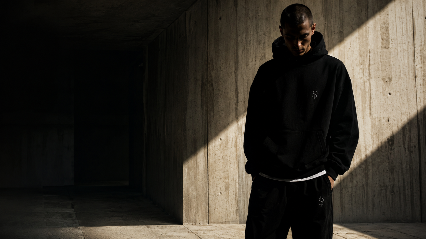 A figure crossing a concrete hall lit by a single diagonal beam of light
