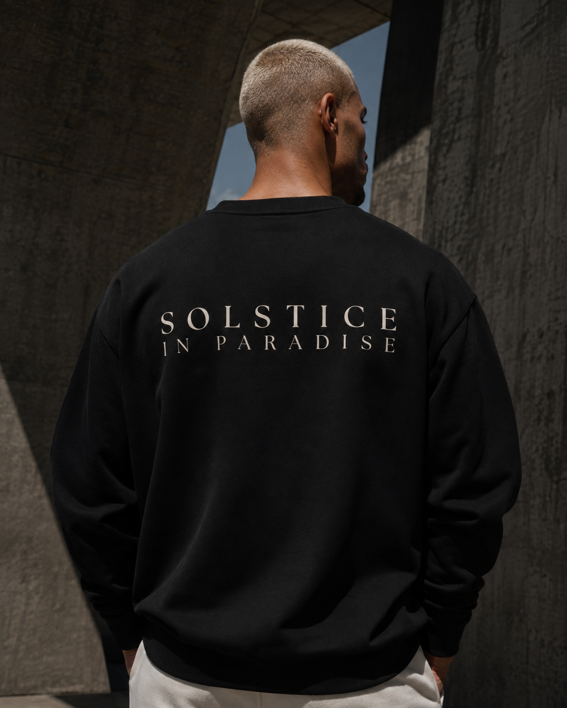 Back of a black sweatshirt with the Solstice in Paradise mark in bone